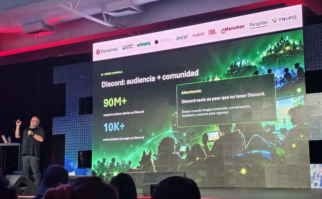 A speaker presenting on stage about Discord's audience and community metrics, with a focus on daily active users and game communities on a large screen behind them. The screen includes statistics and a warning about the importance of content in Discord.